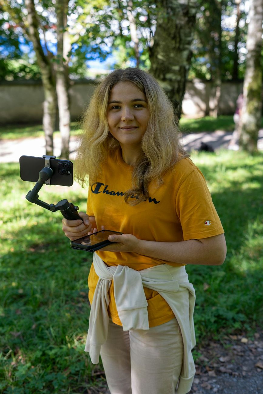 Woman filming herself with a phone on a gimbal outdoors